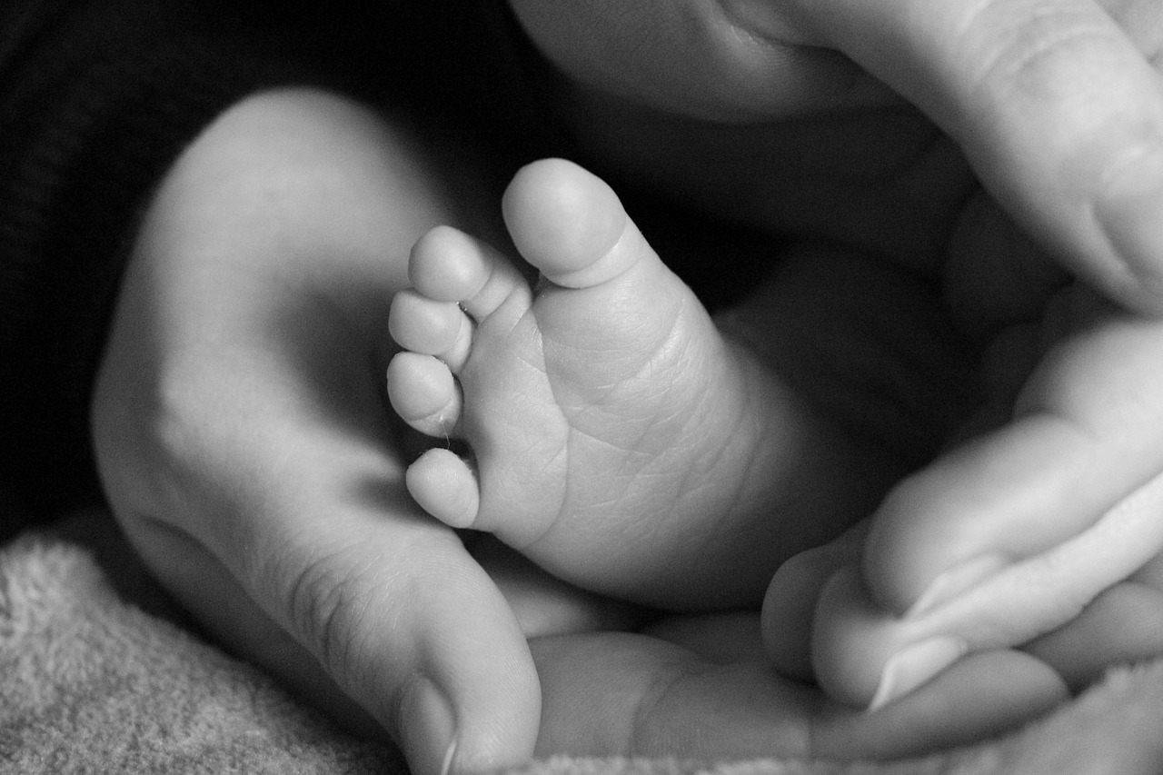 Hands enclosing baby feet, source: pixabay/Kaedesis